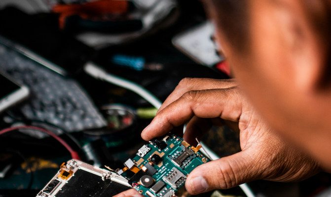 Technician at work on computer chips/board.